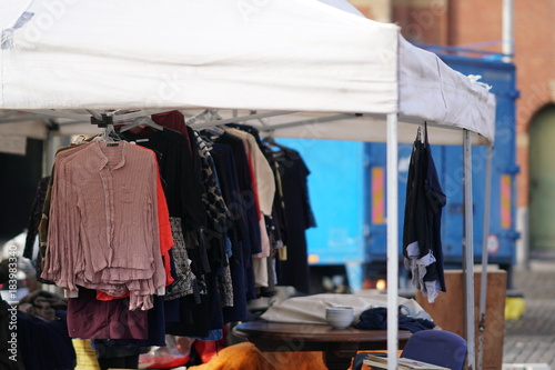 Second hand clothes hanging on a market stall