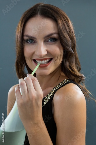 Woman drinking champagne with straw