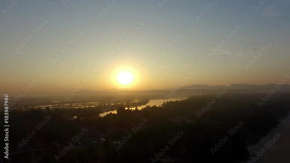 A drone shot of a village under the setting sun.