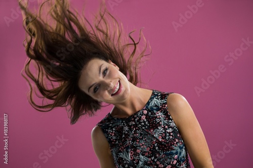 Smiling woman tossing her long hair 