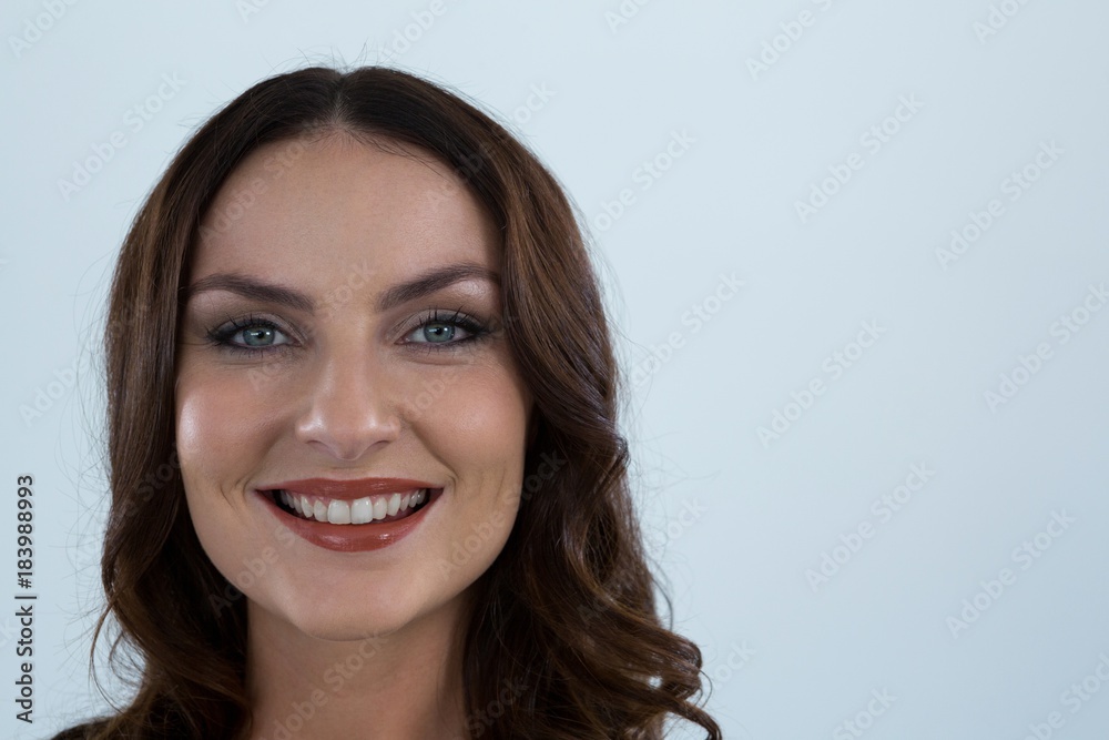 Smiling woman looking at camera against white background Smiling woman looking at camera against white background