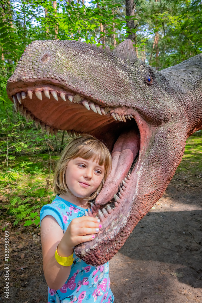 Little girls head in the mouth of a dinosaur