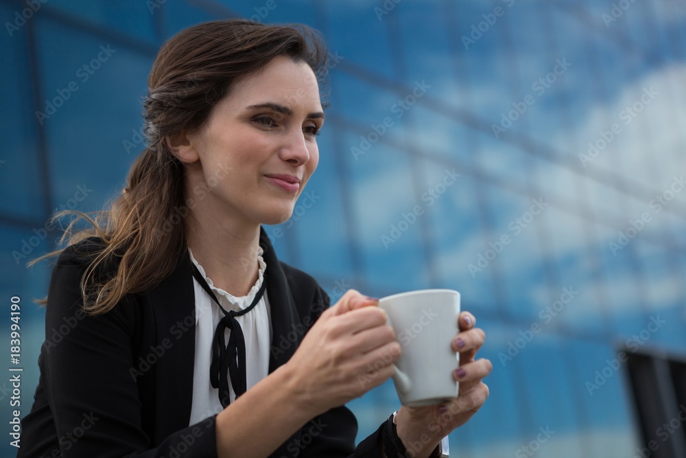 Female executive having coffee in office premises Female executive having coffee in office premises
