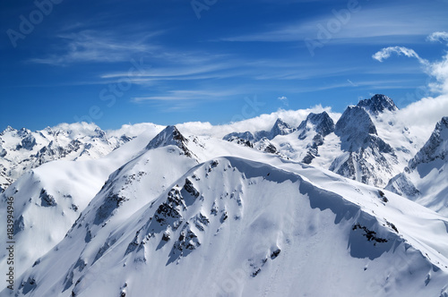 Winter mountains with snow cornice and blue sky with clouds © BSANI