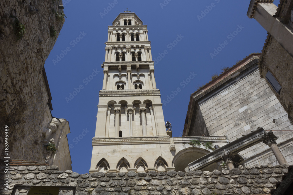 Fototapeta premium Looking up at Saint Domnius bell tower in Split, with Split fortified walls around