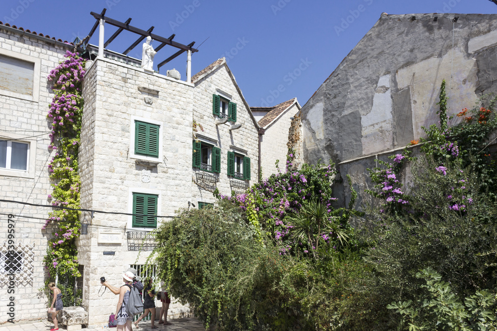 Ancient building in Split in summer season, with many flower and plants