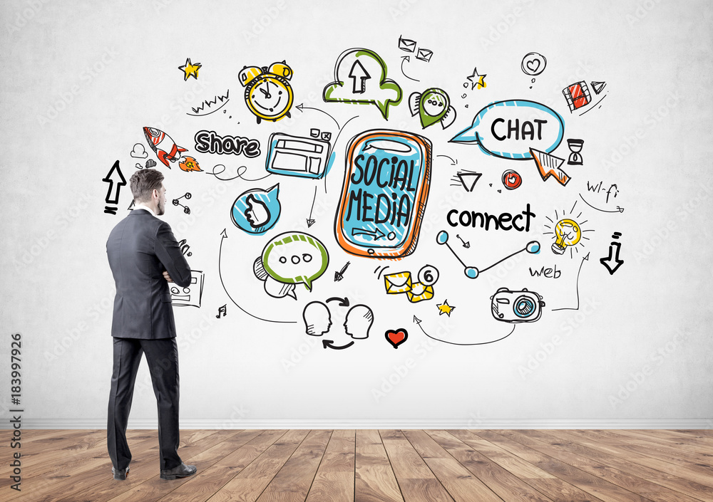 Pensive businessman looking at social media icons Pensive businessman looking at social media icons