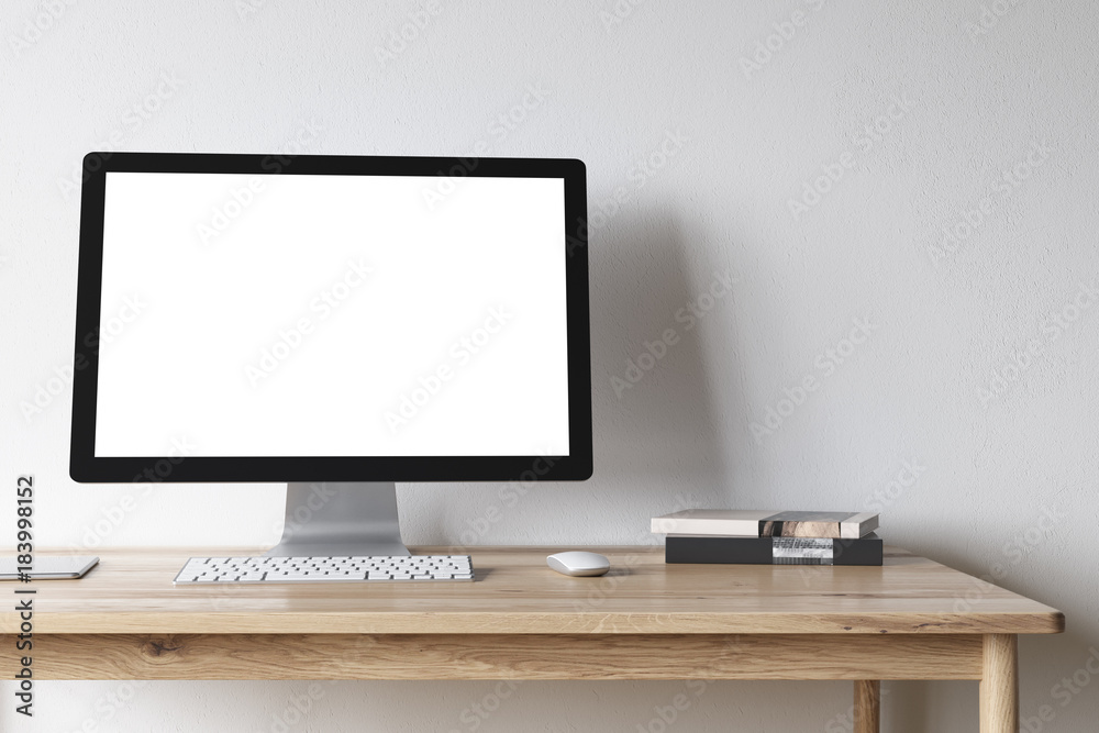 White computer screen on a wooden desk White computer screen on a wooden desk