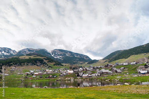 Beautiful idyllic countryside landscape with snowy mountains in background.