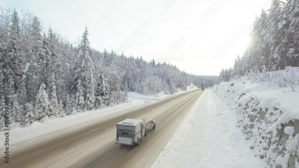Aerial, cars drive through snowy forest in British Columbia Aerial, cars drive through snowy forest in British Columbia