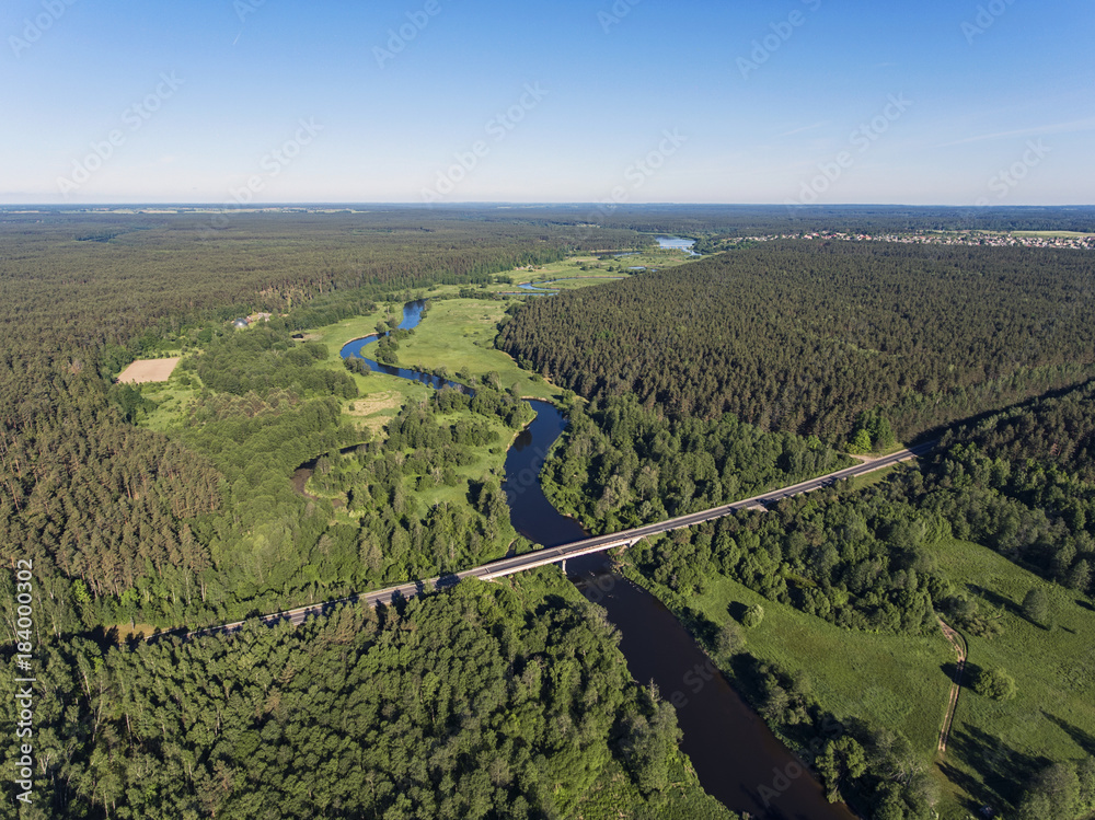 Aerial view over river Merkys valley with the bridge going through near Merkine town, Lithuania. During sunny summer day. Aerial view over river Merkys valley with the bridge going through near Merkine town, Lithuania. During sunny summer day.