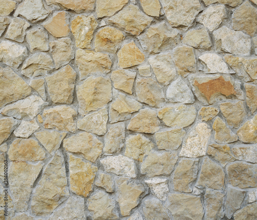 Old yellow stone pavement texture. Ancient natural cobblestone road as background. Abstract background of old cobblestone pavement. Old yellow stone pavement texture. Ancient natural cobblestone road as background. Abstract background of old cobblestone pavement.