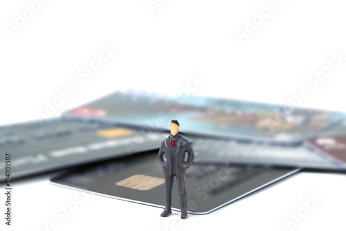 Figure miniature businessman or small people standing with stack of credit card on white background for money and shopping concept.