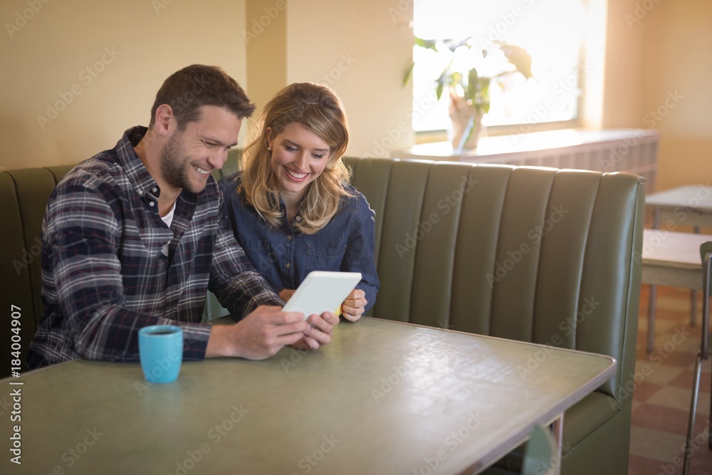 Couple using digital tablet in restaurant Couple using digital tablet in restaurant