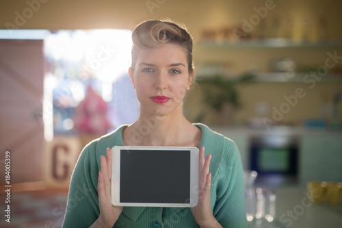 Woman holding digital tablet in restaurant 