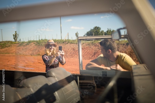 Woman taking a photo of man with mobile phone