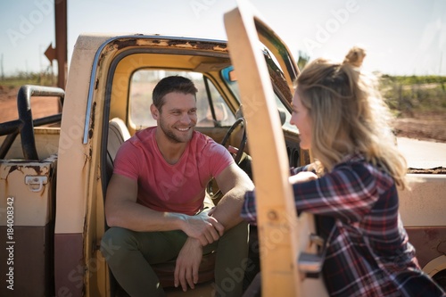 Couple interacting with each other near a car