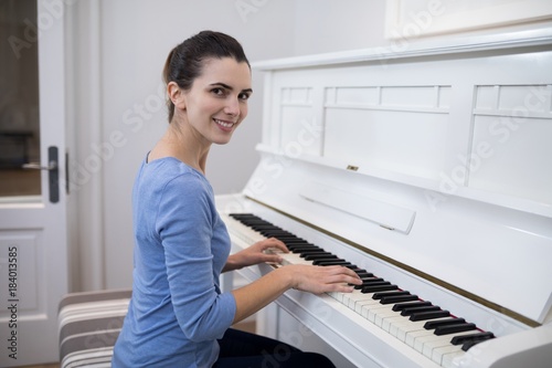 Fototapeta Portrait of beautiful woman playing piano