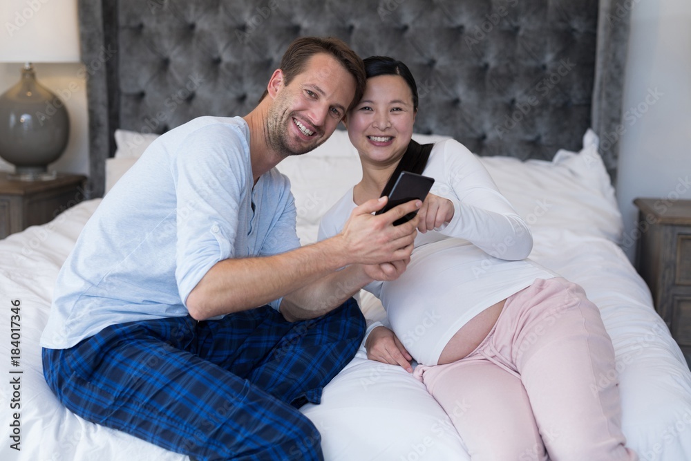 Happy couple reviewing picture on mobile phone Happy couple reviewing picture on mobile phone