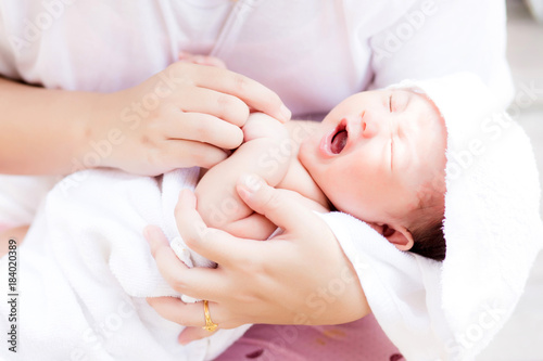Asian newborn in mother's arm after having a bath