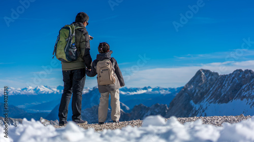 Father And Daughter Stand On Snow Hill