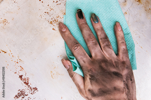 Low-skilled jobs for women. Dirty female hands cleaning surface with a towel photo