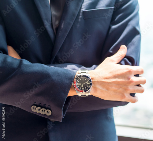 Portrait of young Asian businessman with arms crossed standing in office