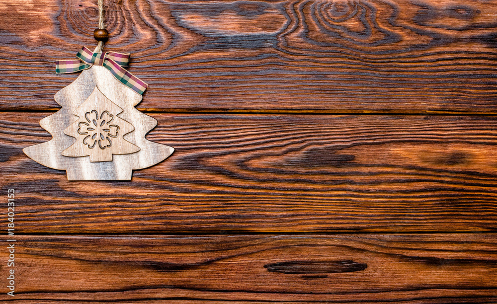 Fototapeta premium Christmas toy lies on a brown wooden background 