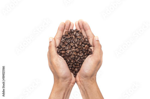 Man's hand with full of Coffee beans isolated over white background.