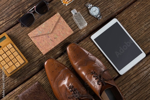 Shoes, digital tablet and sunglasses on wooden plank
