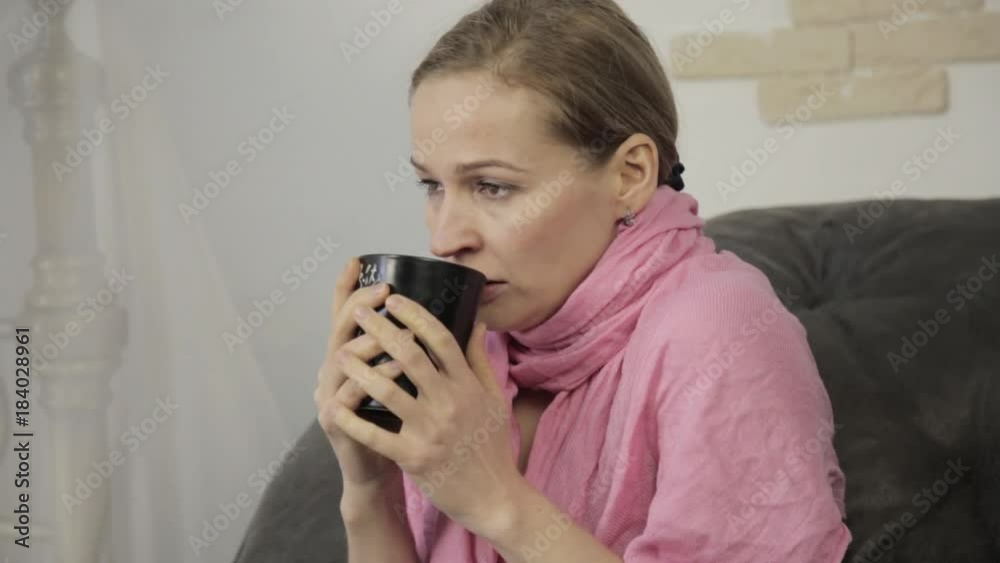 sick woman sneezes loudly, wipes his nose and and drinking hot tea sick woman sneezes loudly, wipes his nose and and drinking hot tea