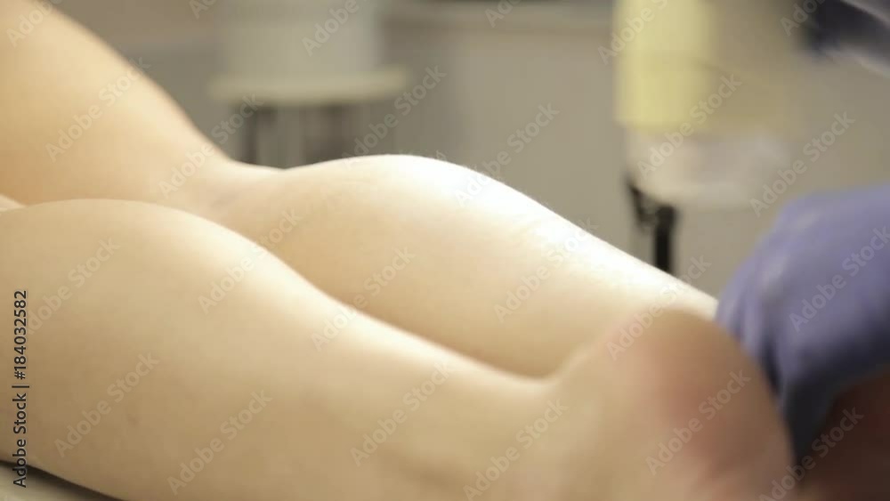 Beautician doing wax depilation to female legs Beautician doing wax depilation to female legs