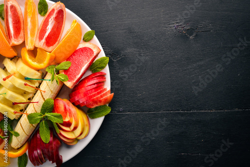 Fruit Slicing. Oranges, grapefruit, banana, mandarin, kiwi. Tagliateli. Free space for your text. Top view. photo