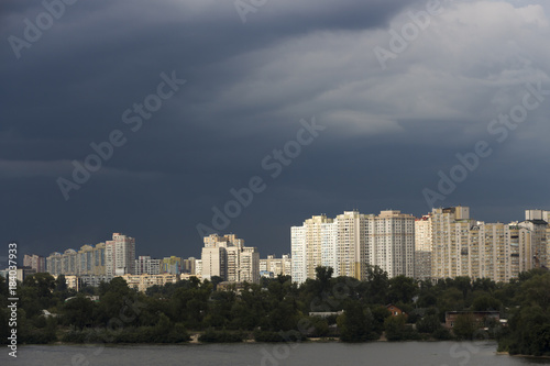 Heavy  stormy clouds of contrasting color over the evening city