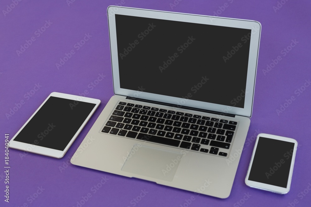 Laptop, mobile phone and digital tablet on purple background Laptop, mobile phone and digital tablet on purple background