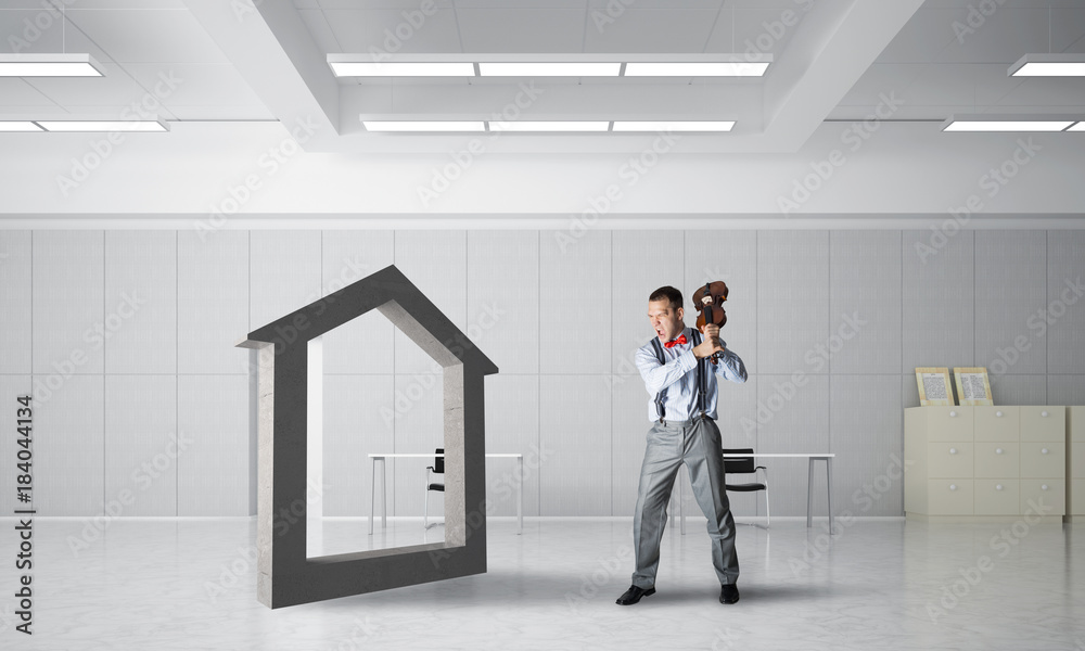 Fototapeta premium Stone home silhouette as symbol for real estate insurance crashed by man
