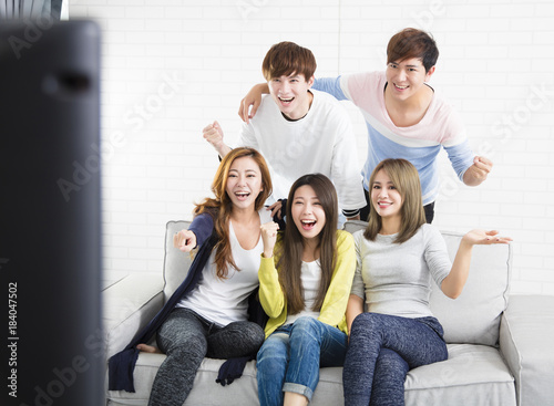 young group Sitting On Sofa Watching TV  show.