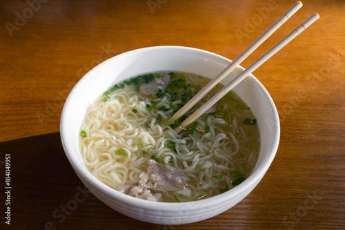 Noodles with meat broth and vegetables in Chinese-style on the sunlight
