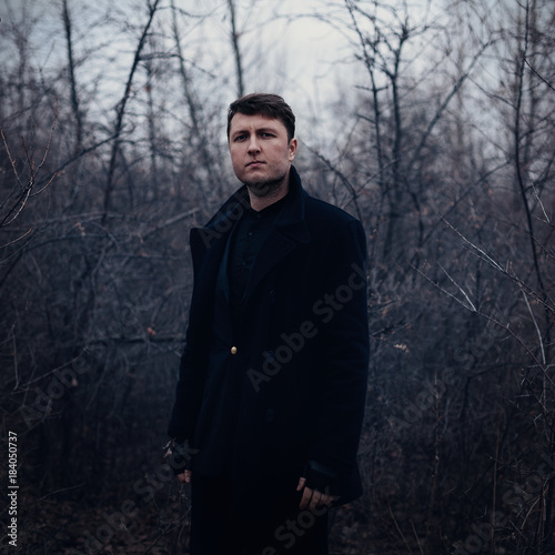 Portrait handsome serious man in coat outdoors in autumn park © Andrii