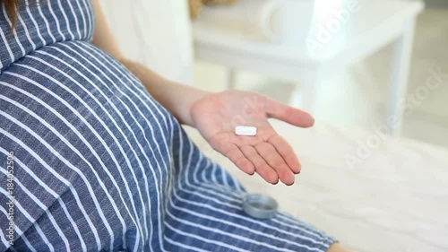 Close-up Of Pregnant Woman Hand With Vitamin Pills. Prenatal medications