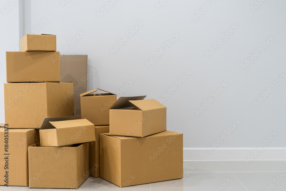 Stack of cardboard boxes in empty room - obrazy, fototapety, plakaty 