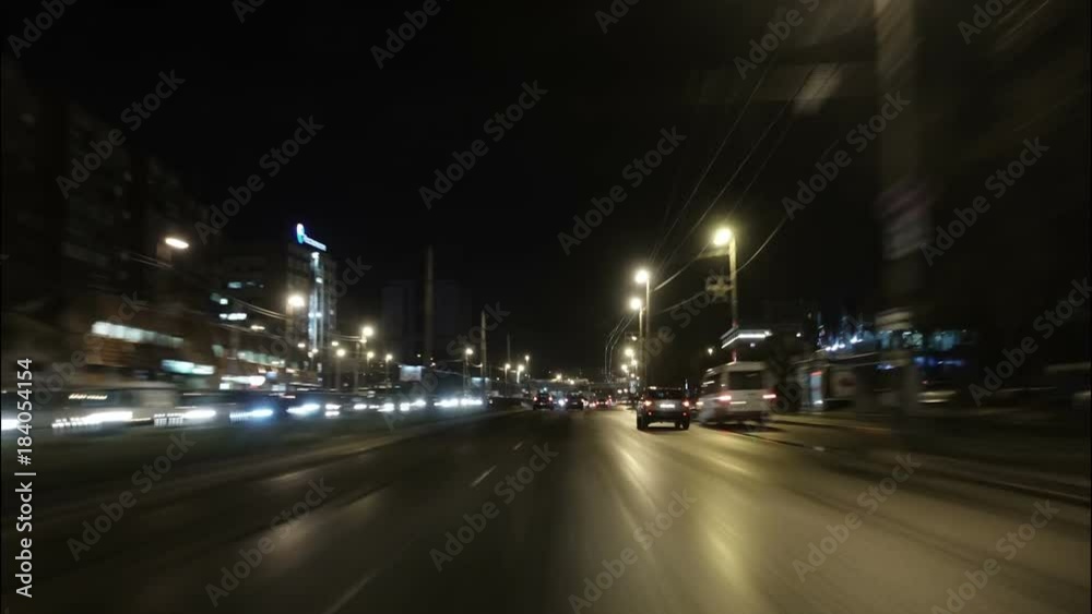 Time lapse of driving a car in the city at night time. POV. Hyper laps in the evening downtown.