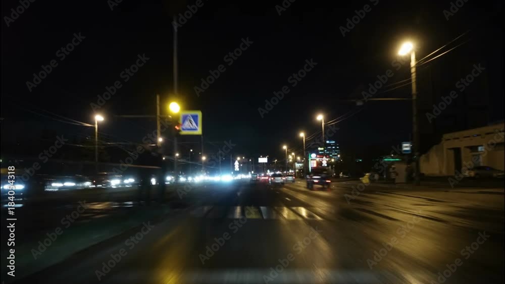 Time lapse of driving a car in the city at night time. POV. Hyper laps in the evening downtown.