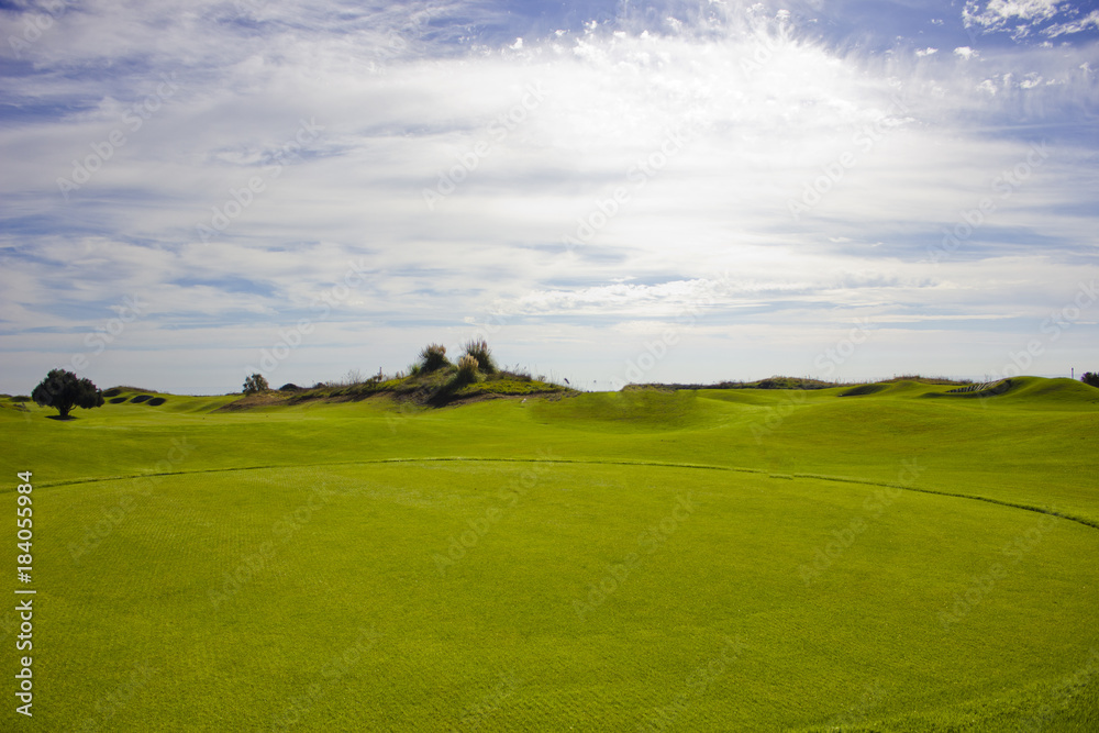 Golf course in Belek. Green grass on the field. Blue sky, sunny day