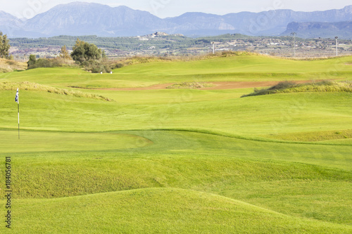 Golf course in Belek. Green grass on a field. Blue sky, sunny day