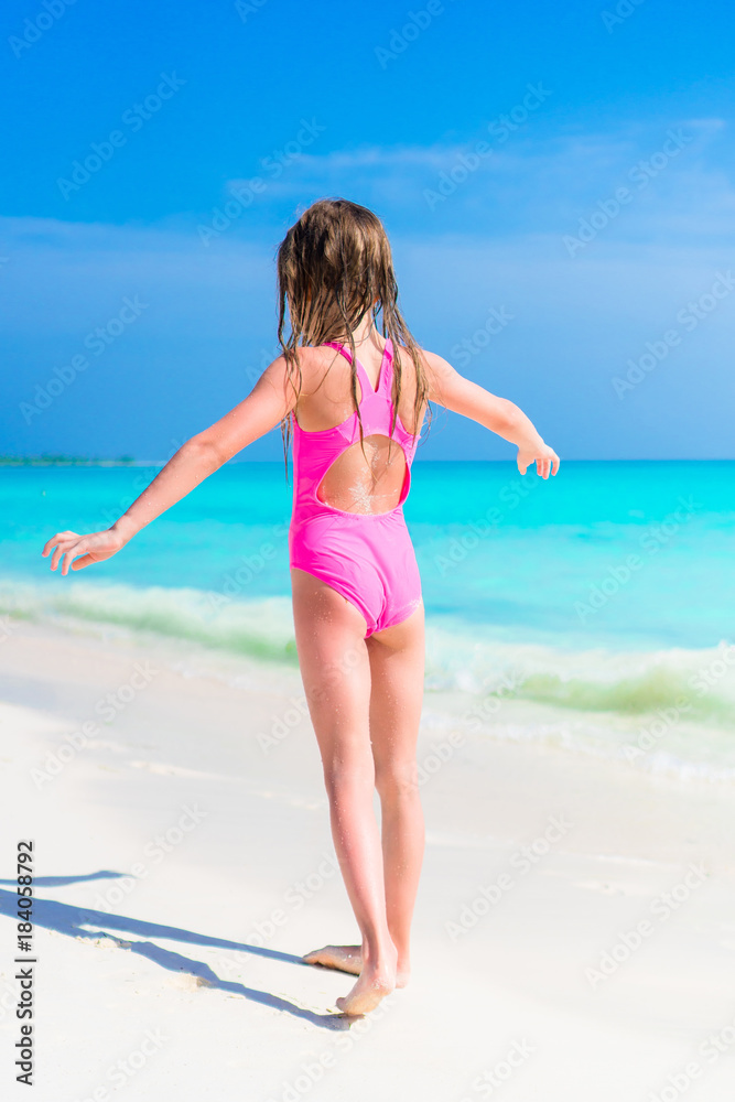 Adorable little girl in swimsuit on beach vacation Adorable little girl in swimsuit on beach vacation