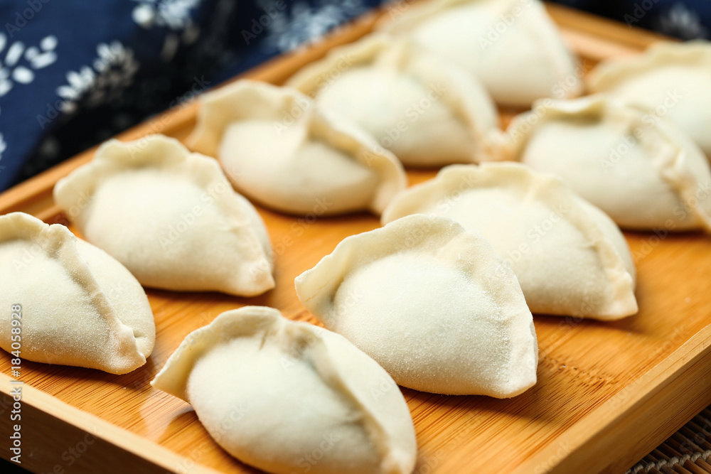 raw dumplings on wooden plate with flour and rolling pin raw dumplings on wooden plate with flour and rolling pin