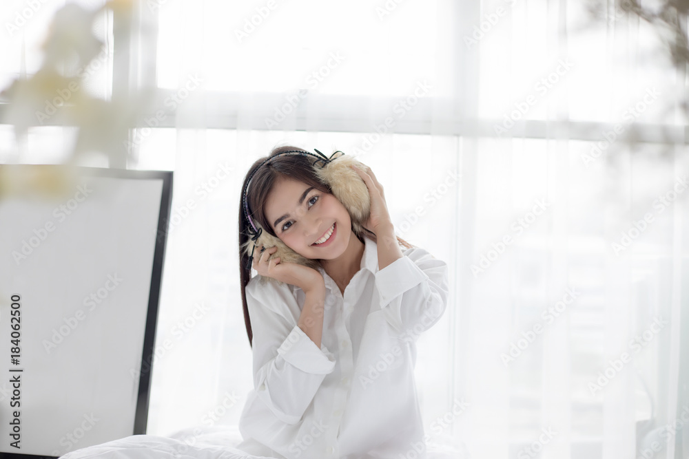 Asian woman Smile feel carefree and she lying on the bed in the morning after waking up and young beautiful girl will listening to music on headphones Asian woman Smile feel carefree and she lying on the bed in the morning after waking up and young beautiful girl will listening to music on headphones