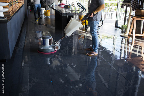 The people cleaning floor with machine.