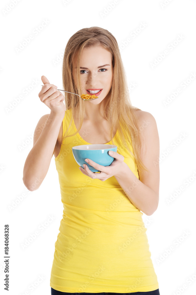 Beautiful caucasian slim woman eating corn flakes.